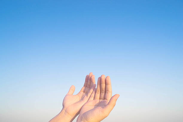 istock two hands and cross of christ and believers 465543918