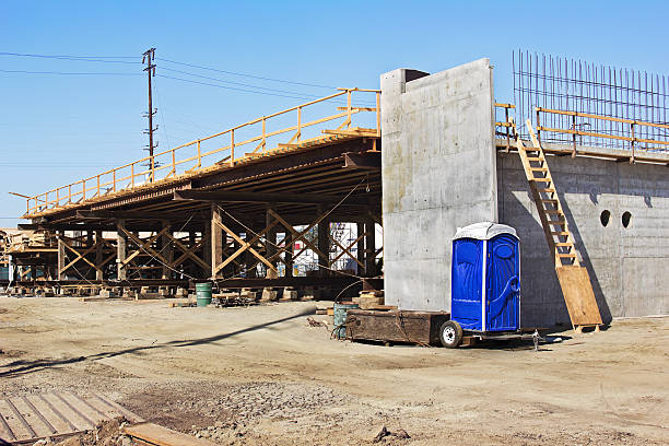 Bridge Construction with Porta Potty Bridge construction begins to go over a road and while a porta potty is good to have on site. railway bridge photos stock pictures, royalty-free photos & images