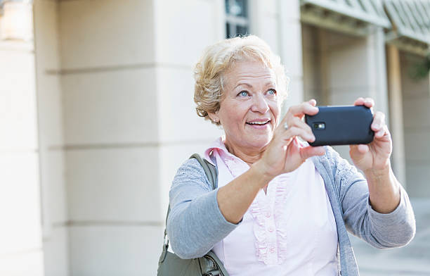 istock Senior woman with camera phone 465546495