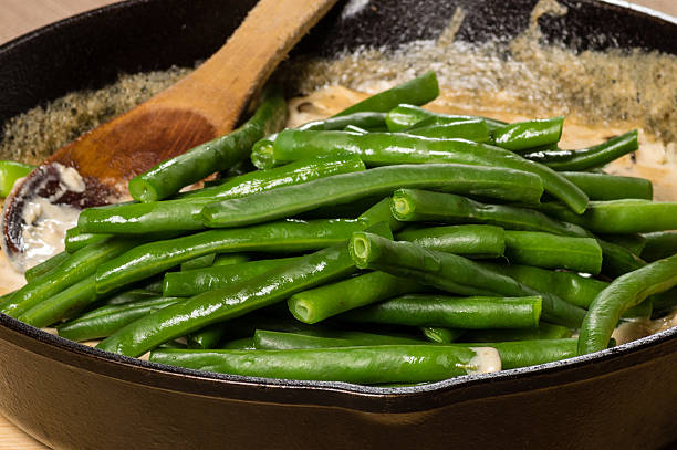 préparation de haricots verts à un ragoût en cocotte - greenbean casserole photos et images de collection