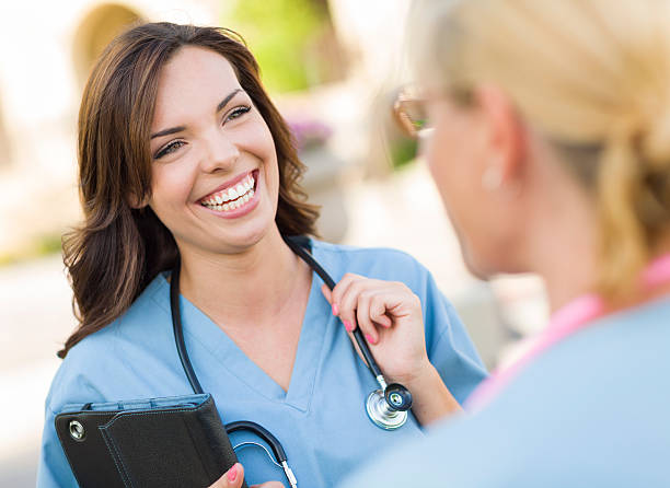 istock Female medical professionals talking outside 465556601