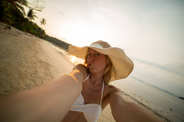 istock Cute woman on beach taking a selfe 465565142