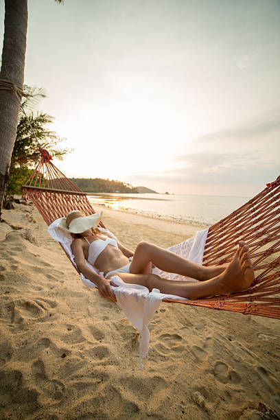 istock Young woman resting on hammock-Beach 465565146