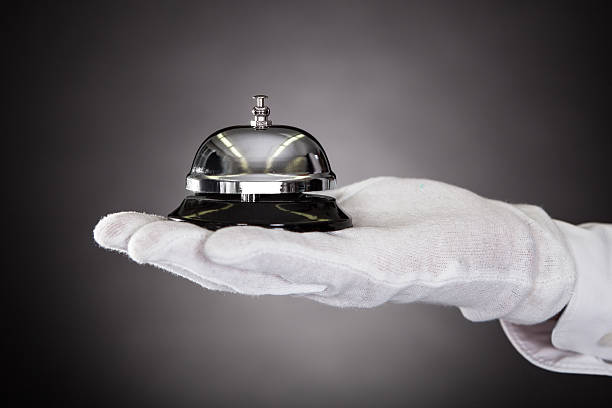 Hand Holding Service Bell Close-up Of Hand With White Gloves Holding Service Bell hotel occupation concierge bell service stock pictures, royalty-free photos & images