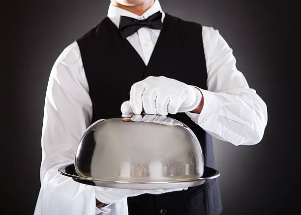 istock Waiter holding a tray with a lid getting ready to open it 465579699