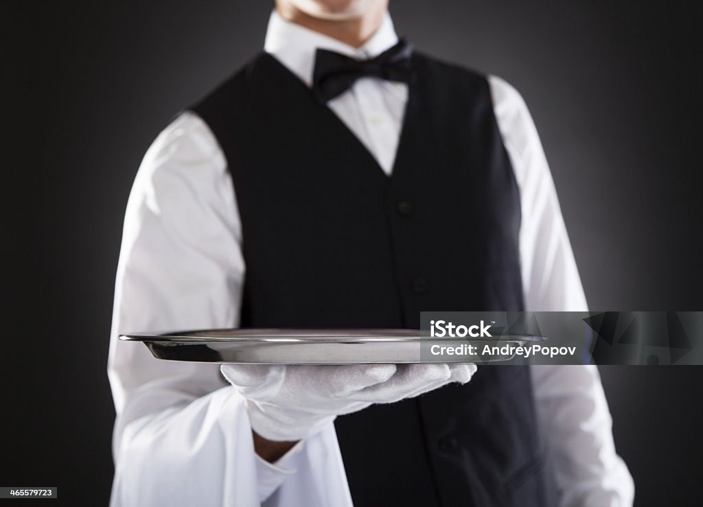 Male Waiter Holding Tray Portrait Of A Male Waiter Holding Tray Over Black Background Waiter Stock Photo