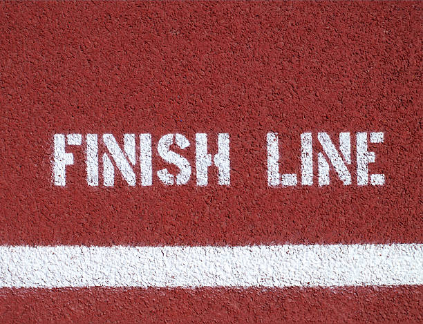 White sprayed on text over a white line on a red background Finish line - sign on the running track end of the line stock pictures, royalty-free photos & images