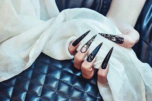 This is photography of black nails that are made by nail artist.