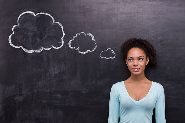 istock Smiling afro-american woman with cloud formed dialog on chalkboard 465594022