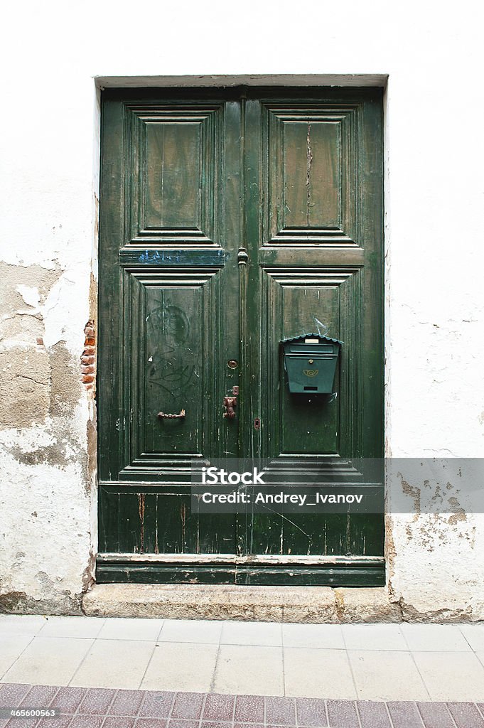 Stary zielone drzwi na białej ścianie - Zbiór zdjęć royalty-free (Architektura)