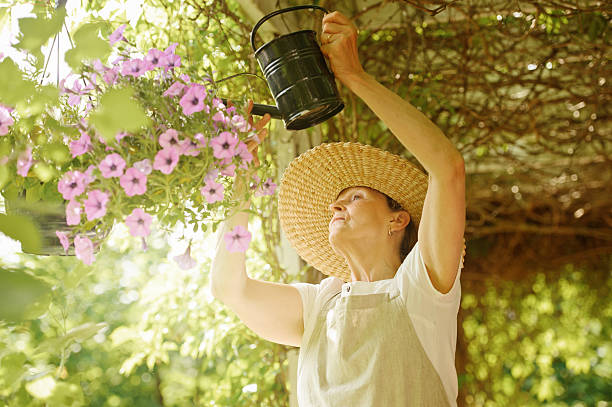 istock senior woman waters flowers 465608766