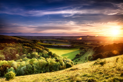 Winchester hill sunset across folding farmland and trees