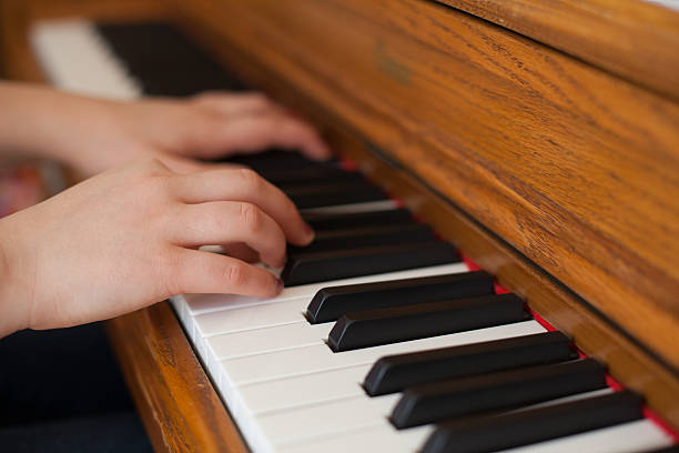 istock Hands of young woman playing piano 465610799