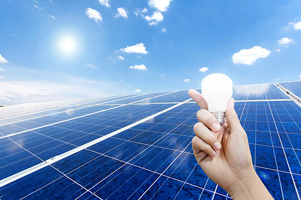 istock Solar energy panels and Light bulb in hand 465611264