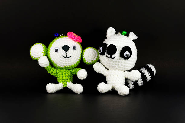 istock handmade crochet monkey and Raccoon doll on black background 465611413