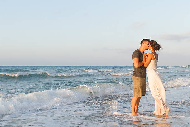 istock Young couple enjoys walking on a hazy beach at dusk 465611780