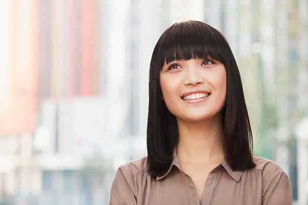 retrato de mujer joven sonriente al aire libre en beijing, mirando hacia arriba - bangs fotografías e imágenes de stock