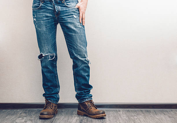 istock Lower half of a man stood in jeans against a white wall 465615742