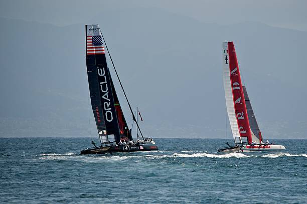 In light winds and calm seas, TP52 sailboats race on Lake Michigan's Little Traverse Bay in the summer month of July. TP52 refers to the Transpac 52 class of racing sailboats.. on an otherwise clear day in Northern Michigan, views were partially obscured by smoke haze from Canadian wildfires.