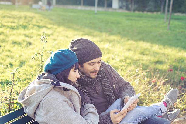 istock couple in love using tablet at the park 465617051