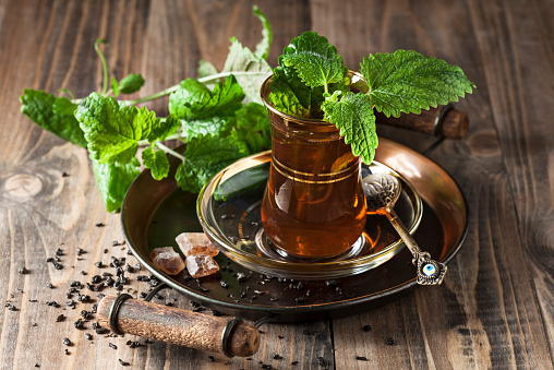 Tea with fresh mint on wooden background