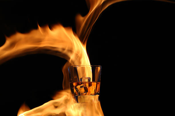 Glass with whiskey in the fire stock photo