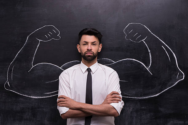 istock Serious businessman with painted muscular arms on chalkboard 465625440