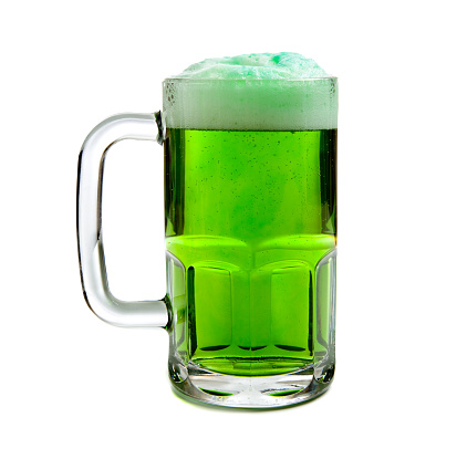 A beer mug of green beer with a foamy head on a white background - St. Patricks Day themd
