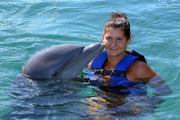 Dolphin kisses woman stock photo