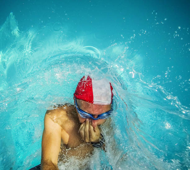 istock Man jumping and diving in swimming pool 465630449