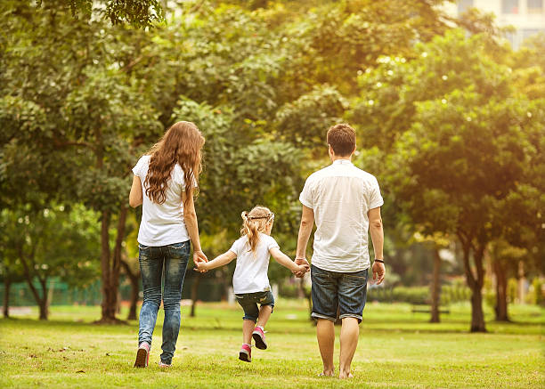 istock Couple walk in the park, holding their daughters hands 465632476