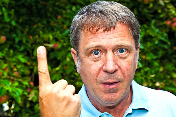 istock man in garden raises his finger to warn 465636253