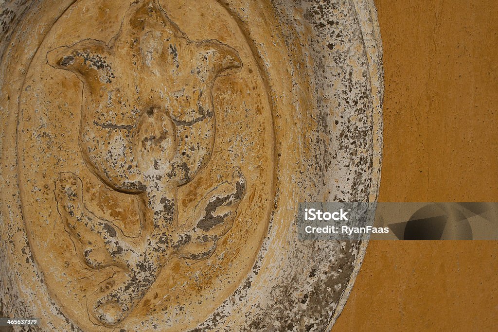 Stone flower carving on stucco wall A stone flower ornament carved onto an old stucco wall Antique Stock Photo