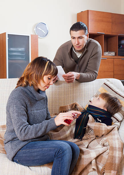 istock parents giving medicinal syrup to  son 465638231
