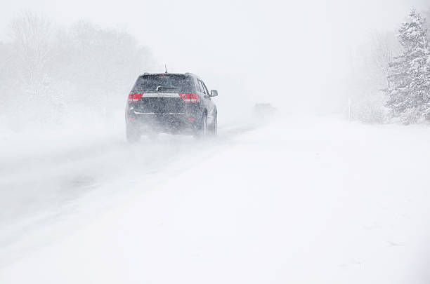 istock Snowstorm on the road in winter forest 465644197