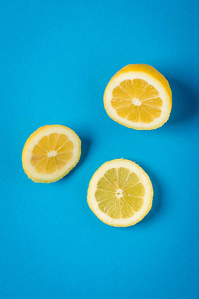 istock Yellow lemon on blue paper background, minimalist still life 465645890