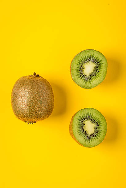 istock Kiwi on yellow paper background, minimalist still life 465645900