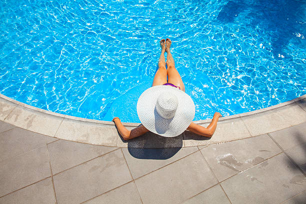 istock woman relaxing at a resort swimming pool 465646032