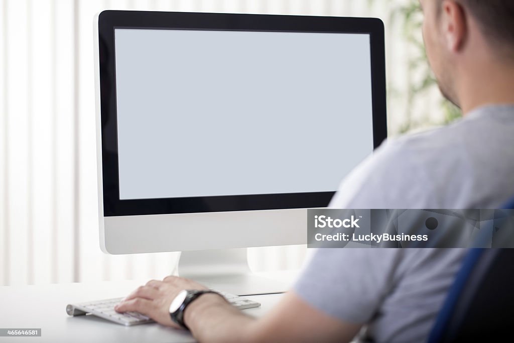 Homem olha para uma tela de computador em branco - Foto de stock de Computador desktop royalty-free