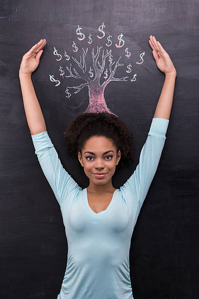 istock Afro-american woman near dollar tree painted on chalkboard 465649780