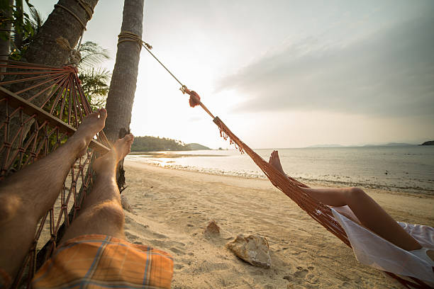 istock Serene people relaxing on hammock at sunset on tropical beach 465653292