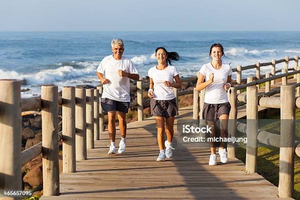 Fit Family Jogging At The Beach Stock Photo - Download Image Now - Adult, Athleticism, Daughter