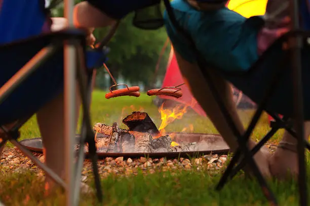 Photo of Campers Roasting Hotdogs in Open Fire Pit