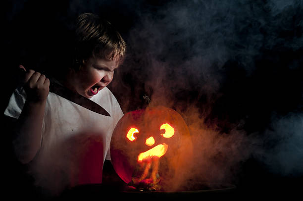 Jack-O-Lantern A crazy young boy carving a jack-o-lantern pumpkin throwing up stock pictures, royalty-free photos & images