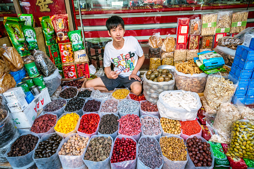 Bangkok, Thailand - December 19, 2014: Street vendor selling sweets and spices at a stall in Bangkok's Chinatown. 