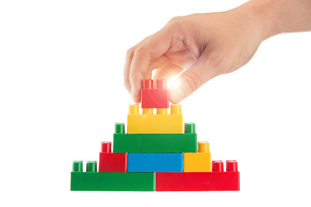 istock Hand building the toy pyramid isolated on white 465669161