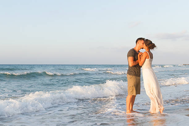 istock Young couple enjoys walking on a hazy beach at dusk 465669894