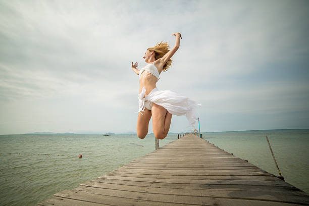 istock Successful woman jumping on wooden pier 465682334
