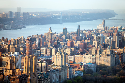 elevated view of buildings in Upper West Side of Manhattan, below is visible Central Park, Hudson River and George Washington Bridge in the background