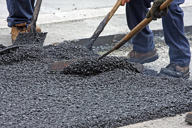 istock Spreading Hot Asphalt On A Road Repair Site 465690328